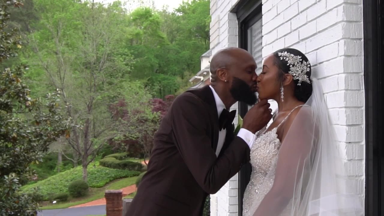 Still from the Anjanette and Ritchie highlight film: a kiss against the white brick