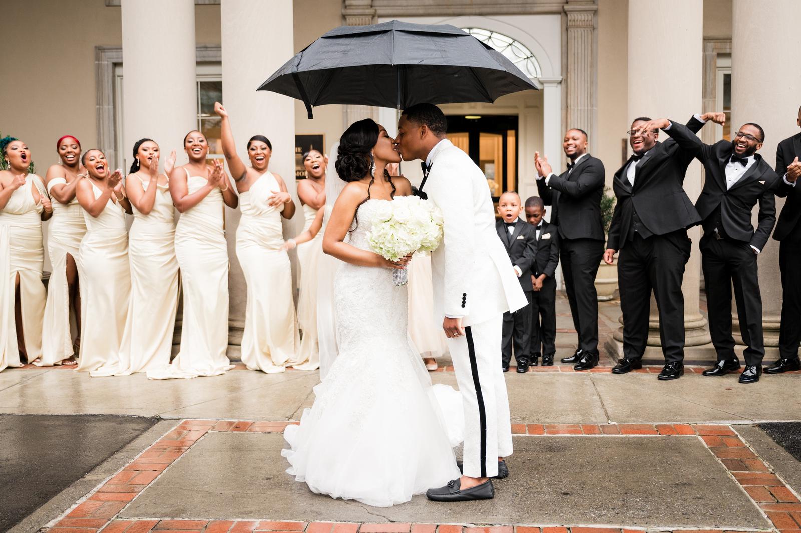 Haley and Kordel kissing under an umbrella