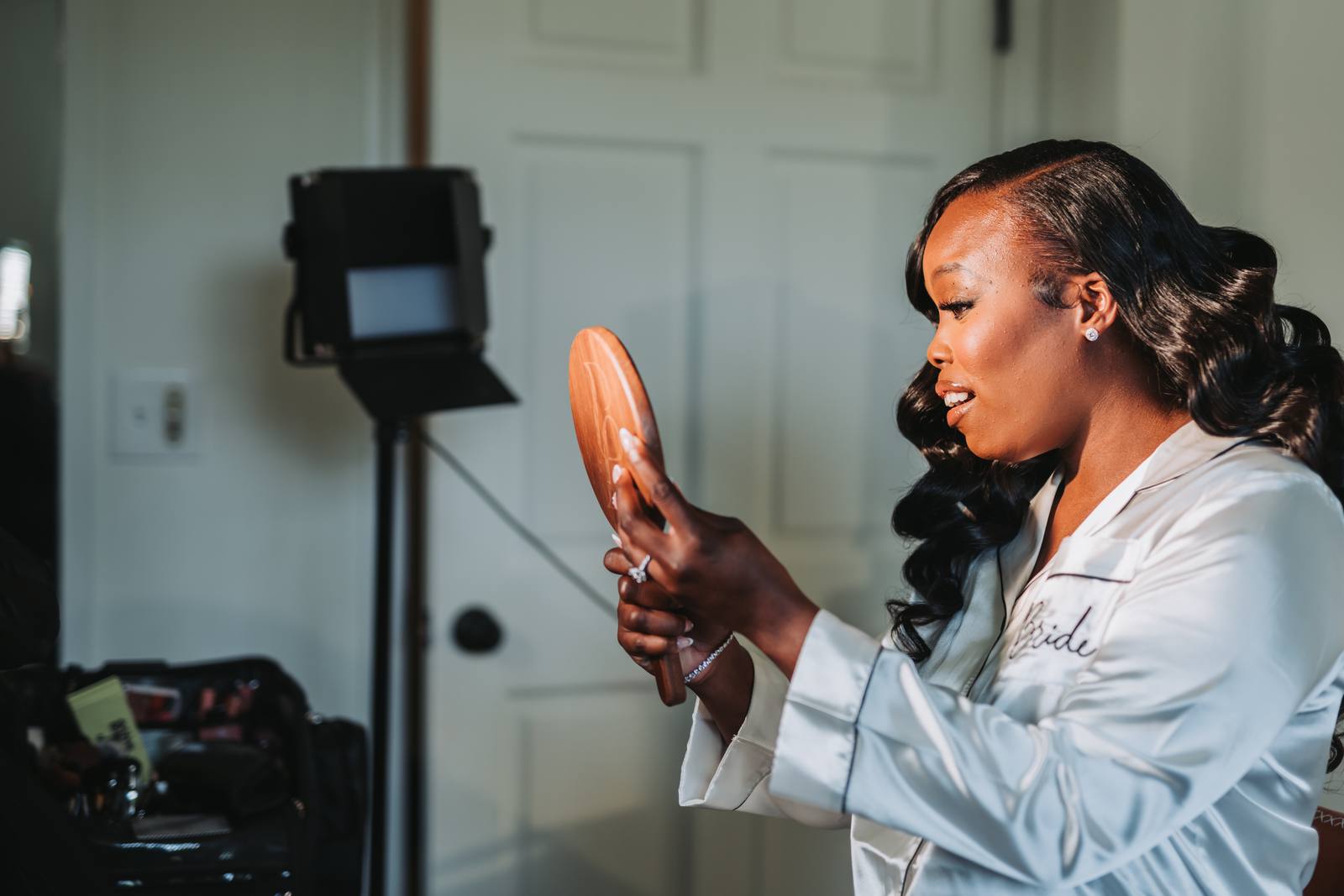 Latisha checking her look in a hand mirror
