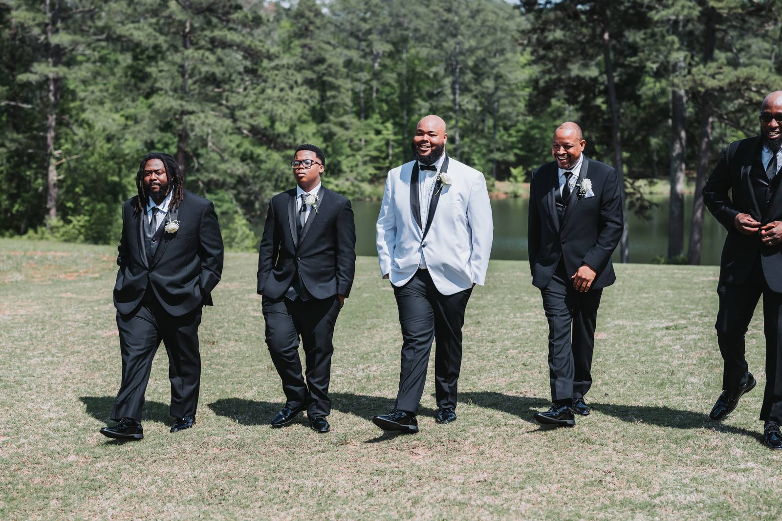 Groomsmen lined up by the lake