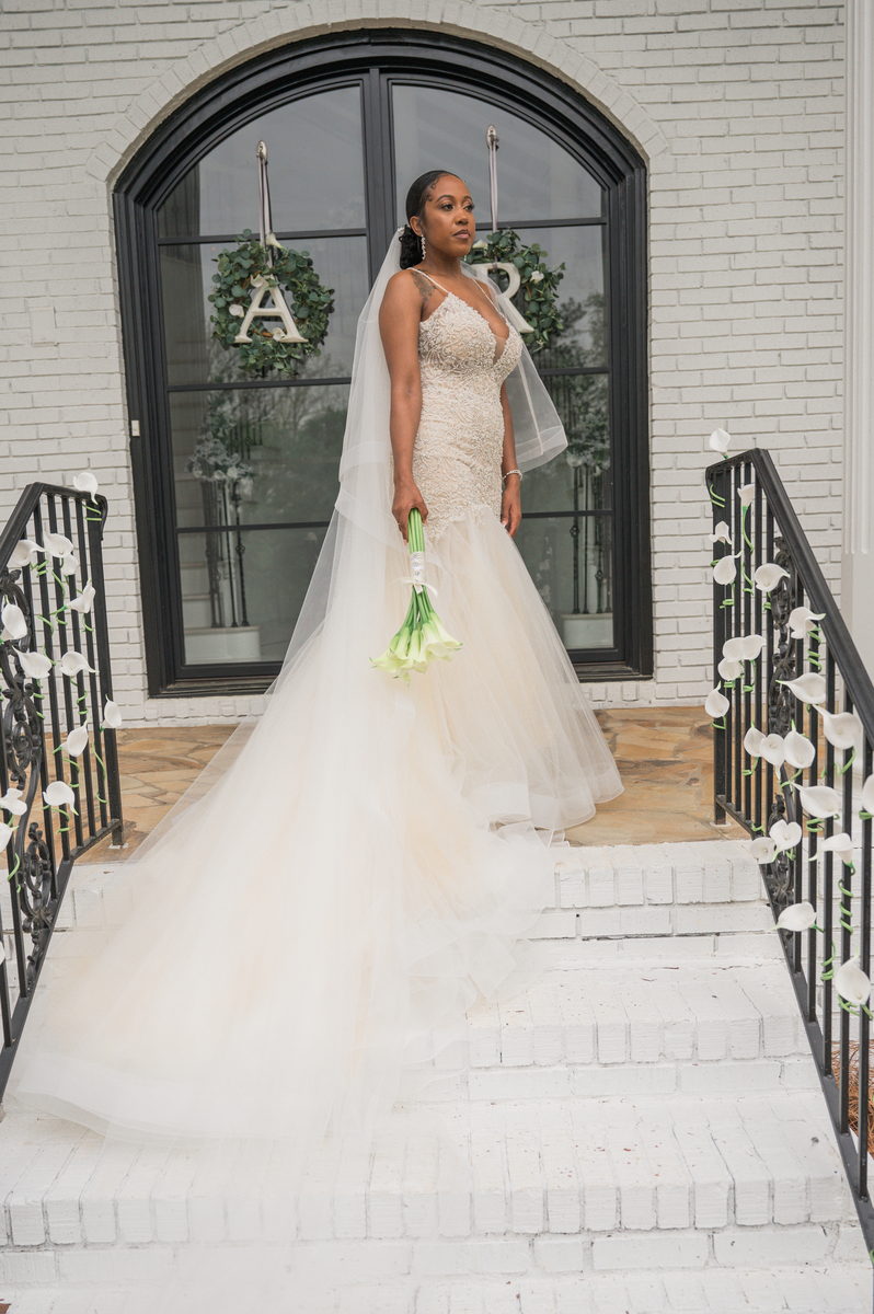 Anjanette on white steps beneath an A and R wreath