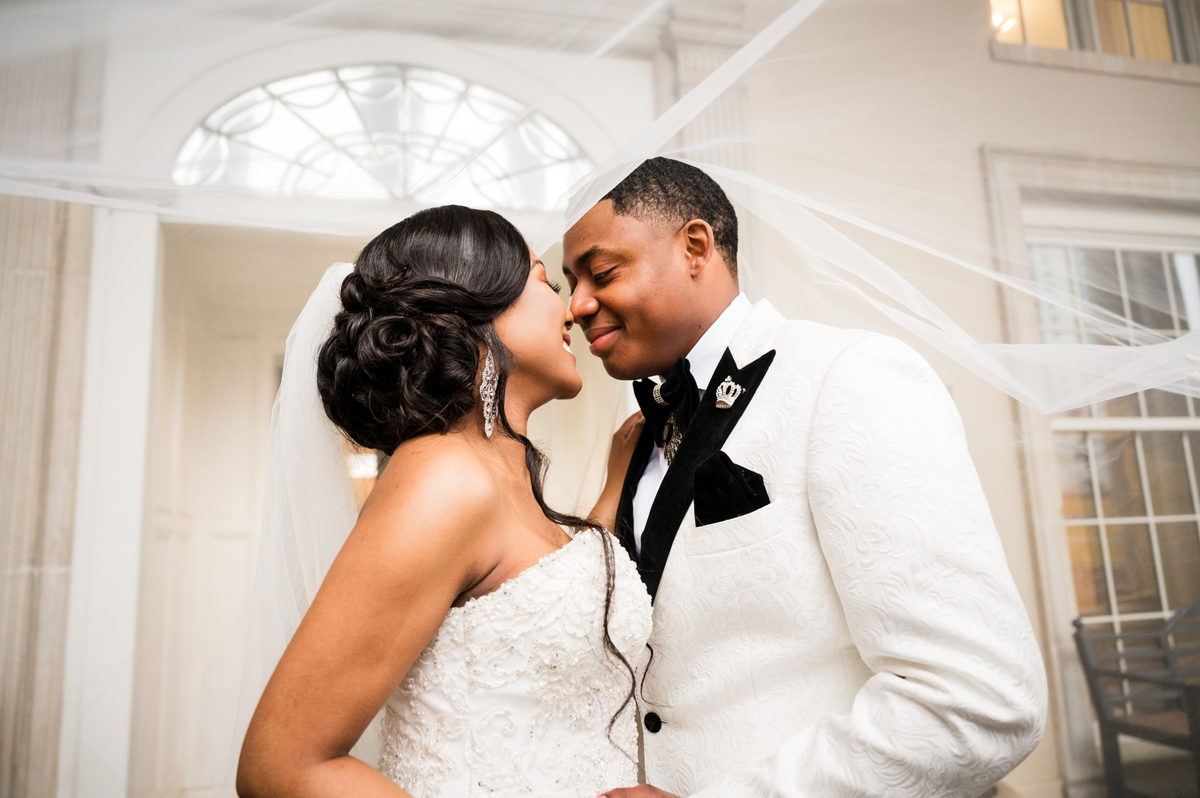 Haley and Kordel nose to nose, veil blowing, arched window