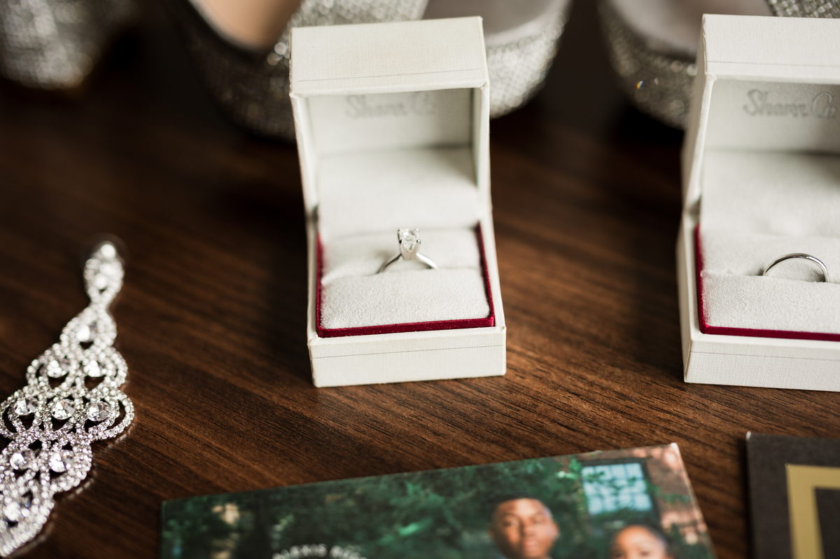 Rings in boxes and earrings on dark wood