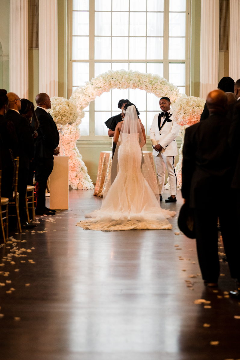 Haley entering, backlit by a window, petals on the floor