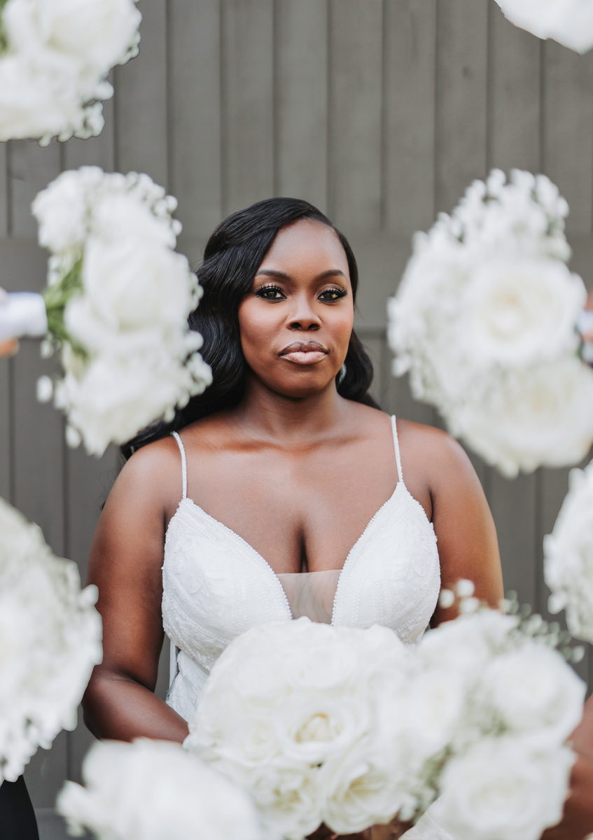 Latisha, framed by white florals, looking straight into the camera