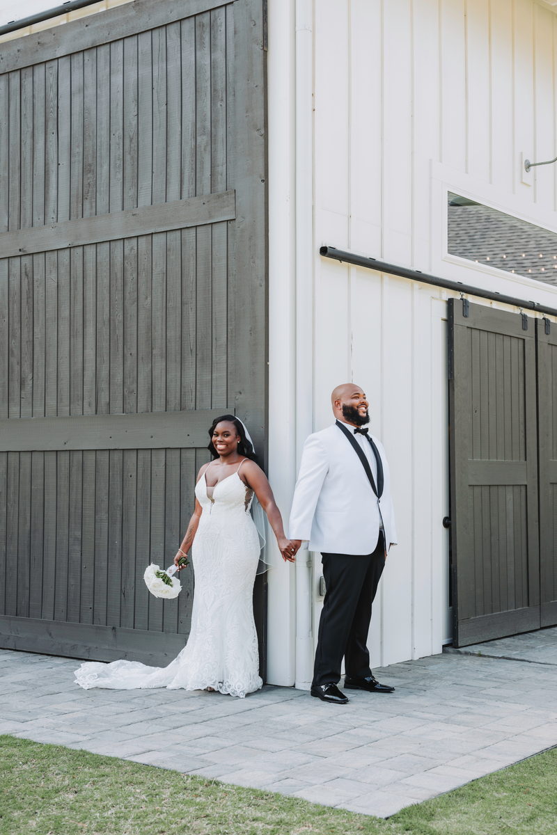 Nate and Latisha hand in hand by the barn door