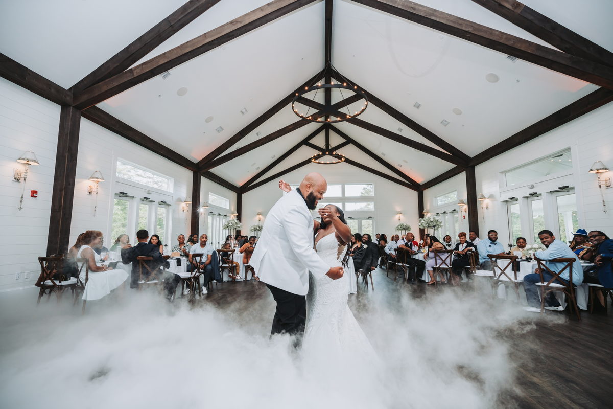 Nate and Latisha's first dance in fog beneath timber beams