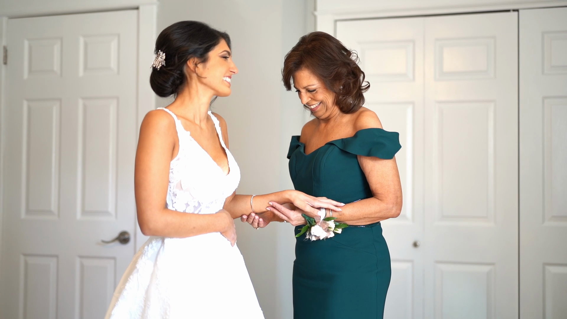 Alyssa and her mother fastening a bracelet, laughing