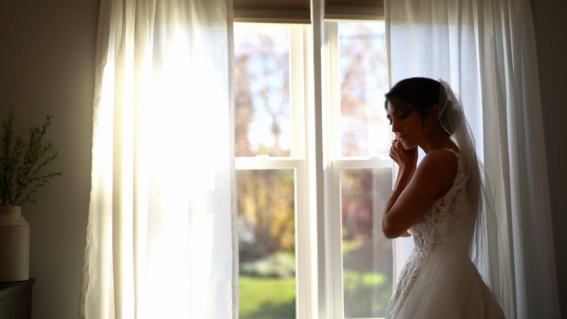 Alyssa alone at the window, backlit through the veil