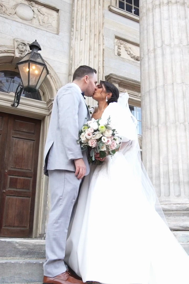 Alyssa and Will kissing on the steps beneath the columns and lantern