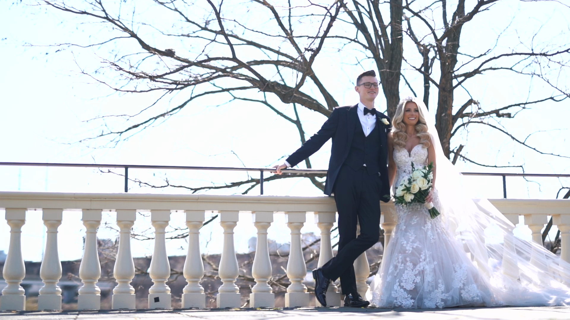 Laura and Lucus on a stone balustrade beneath a bare tree