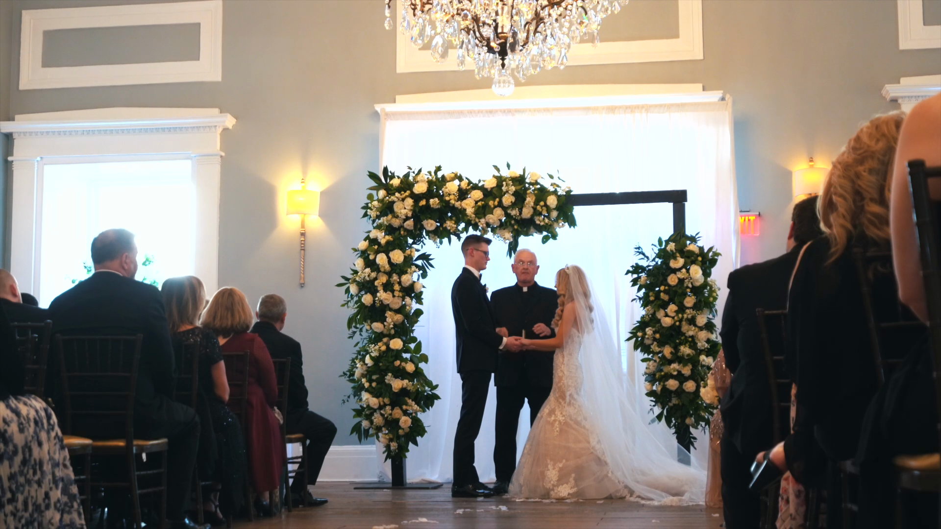 Laura and Lucus at the altar beneath a floral arch