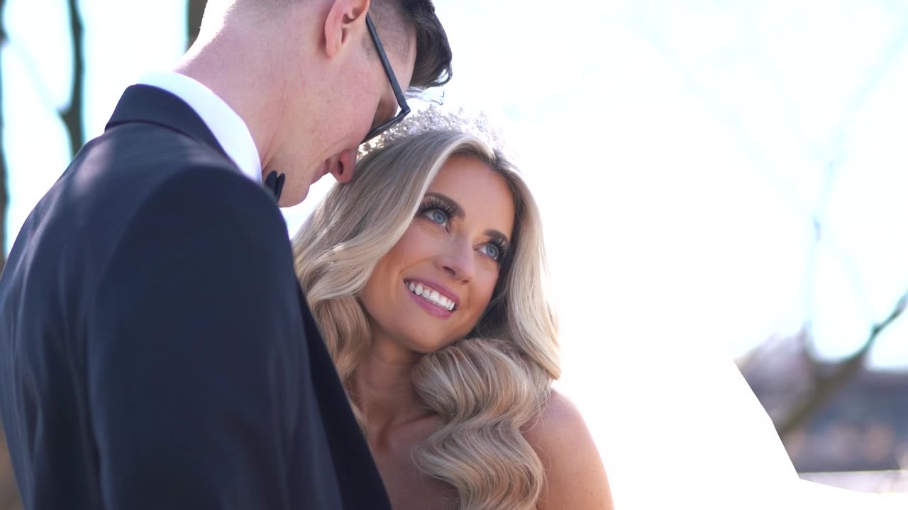 Still from the Laura and Lucus highlight film: Laura smiling up at Lucus, tiara catching the light